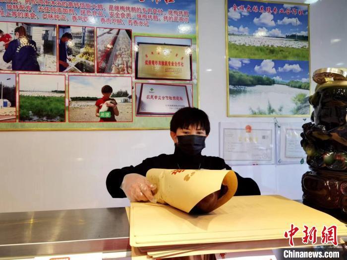 圖為鄭繼梅正在打包烤鵝?！≈x宏秀供圖